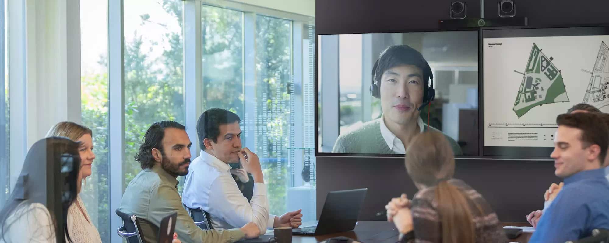 salle de réunion avec le personnel et le travailleur à distance sur écran
