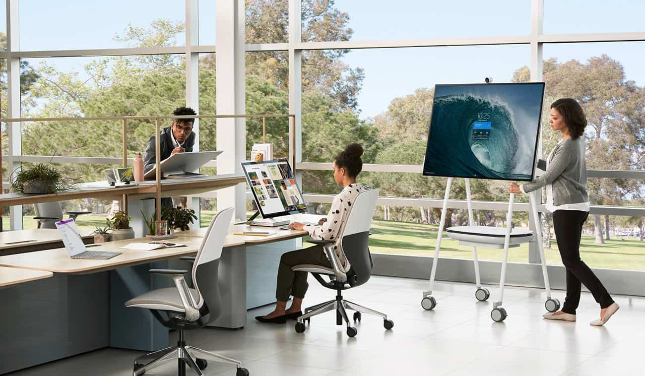microsoft surface hub 2s being pushed into a new work area on its portable cart