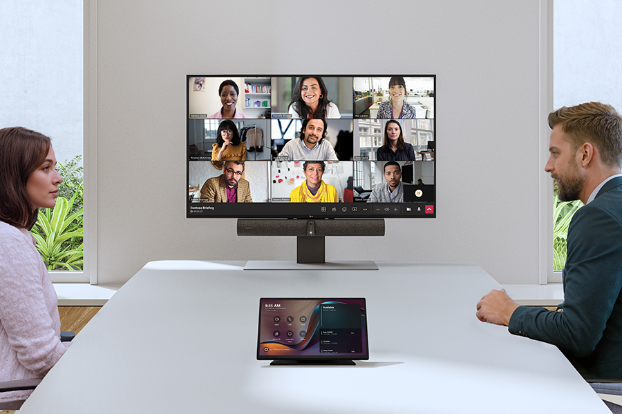 Two people in a Microsoft Teams Room hosting a hybrid meeting with remote participants.