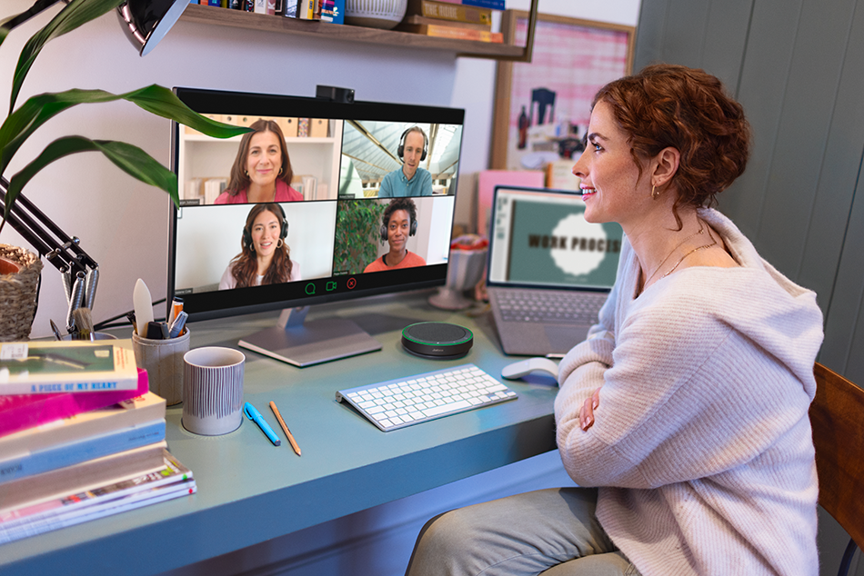 Professional using Jabra desktop speakerphone while joining a hybrid video meeting from a home workspace